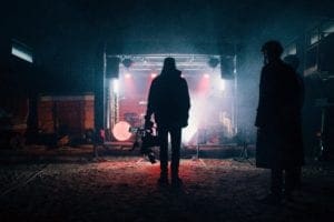 A filmmaker standing in front of lights on a stage