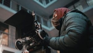 A camera operator operating a camera in the cold. Used on the FilmLocal homepage.